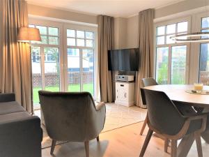 万根沃格Ferienwohnung Strandmuschel的客厅配有桌椅和电视。