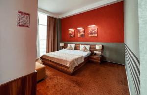巴库Avenue Hotel Baku by Smart的一间卧室设有一张床和红色的墙壁