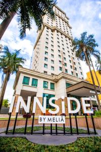 圣保罗INNSiDE by Meliá São Paulo Iguatemi的棕榈树建筑前的标志