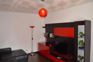 蒙蒂戈杜Casa Rosa的带电视的客厅和红色娱乐中心