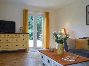 BlencogoBlaithwaite Cottage的客厅配有沙发和鲜花桌