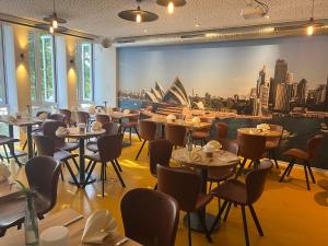不莱梅Kangarooms - Schlachte Weserpromenade的餐厅设有桌椅,享有歌剧院的景色