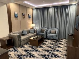 艾卜哈Aman Hotel Suites的客厅配有沙发和两把椅子