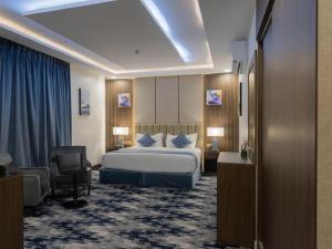艾卜哈Aman Hotel Suites的配有一张床和一把椅子的酒店客房