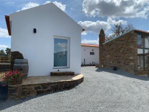阿尔莫多瓦Monte Clérigo Casas de Campo的白色的房子,有窗户和石头建筑