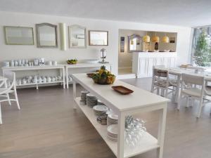 埃斯特角城Atlántico Boutique Hotel的白色的厨房,配有桌子和盘子