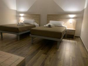 梅尔菲Masseria Spinale Wine Resort的铺有木地板的客房内的两张床