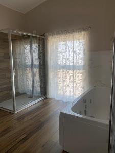 梅尔菲Masseria Spinale Wine Resort的带浴缸的浴室和大窗户