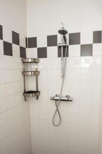 LiempdeDe Donksehoeve的浴室铺有黑白瓷砖,设有淋浴。