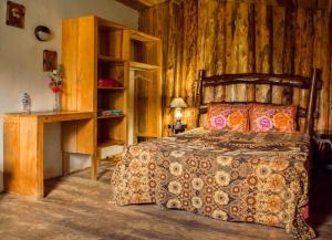 Las CrucesAlla Arriba的一间卧室设有一张床和木墙