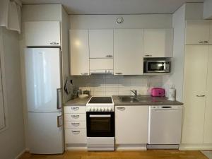 罗瓦涅米River的厨房配有白色橱柜和白色冰箱。