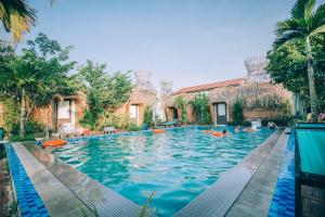 宁平Tam Coc Sky Bungalow的度假村的游泳池,人们在里面游泳