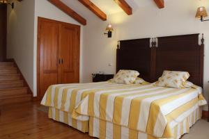 奥比多斯卡萨德坎普塞拉斐尔乡村民宿的一间卧室配有一张黄色和白色条纹的大床