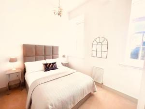 因弗内斯Great Glen Townhouse Inverness的白色的卧室设有一张大床和一个窗户