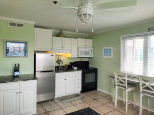 来特斯维比奇Sandpeddler Inn and Suites的厨房配有白色橱柜和冰箱。