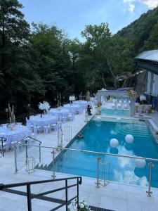 伯伊莱海尔库拉内Hotel Holiday Maria的一个带白色桌椅的游泳池