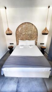斯基亚索斯镇Mamma Mia apartments skiathos的一间卧室配有一张带两盏灯的大型白色床。