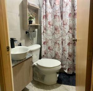 瓜亚基尔Garzota Suites Gardens的浴室设有卫生间、水槽和淋浴帘