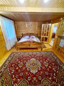 亚列姆切Садиба "Три Царі"的一间设有一张红色大地毯的床的房间