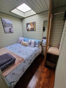 霍利黑德Stunning 1-Bed shepherd hut in Holyhead的一间小卧室,房子里配有一张床铺
