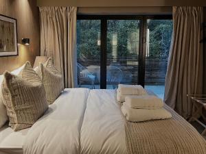 拉姆斯博滕Apartments for two in Brand New Luxury Rural Farmhouse Escape的卧室内的一张带白色床单和枕头的床