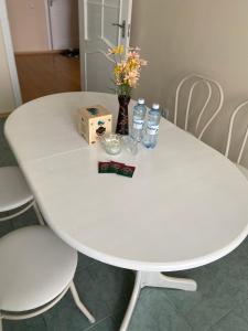 阿斯塔纳Апартаменты в центре города的一张带瓶装水和鲜花的白色桌子