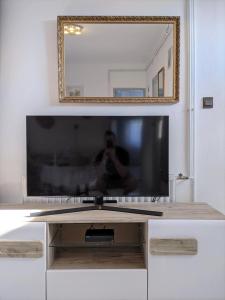 鲍洛通费尼韦什Marica Apartman的白色橱柜顶部的平面电视