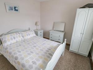 朗德斯通Sea Watch House的一间卧室配有一张床、一个梳妆台和电视。