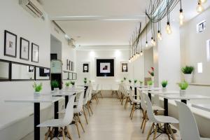 布宜诺斯艾利斯Believe Madero Hotel的一间长餐厅,配有白色的桌子和椅子
