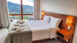 蒙特韦尔迪Chalés Mirante Monte Verde的一张位于酒店客房的床铺,设有大窗户