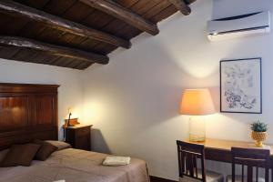 巴勒莫Attico con terrazza sul porto的一间卧室配有一张床和一张带台灯的书桌