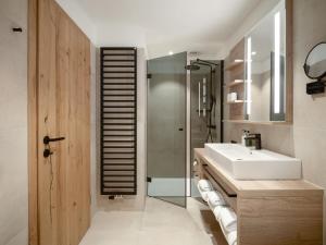 比特亨巴赫布肯巴真霍夫酒店的一间带水槽、淋浴和镜子的浴室