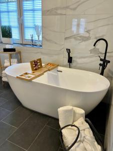 诺费尔登JUNIPRO Luxury Apartments的浴室内设有大型白色浴缸。