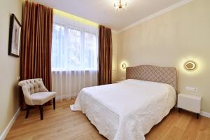 考纳斯Luxury Central Apartment in Putvinskio street的卧室配有床、椅子和窗户。