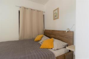 萨格勒布Hill apartman - MAKSIMIR Rebro的一间卧室配有一张带黄色枕头的床。