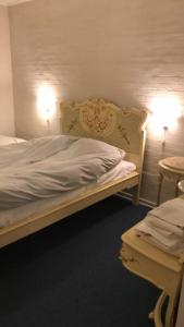 BredebroMotel Lido的一间卧室配有一张床、两盏灯和一张桌子。