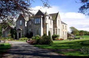 Kilconquhar基尔康克尔城堡酒店的前面有车道的大型石屋