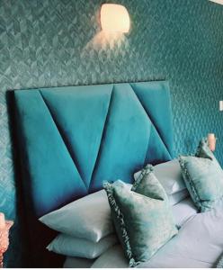 约翰内斯堡Boutique Stay的一张带枕头的蓝色床头板的床