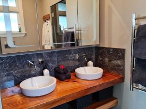 玛塔玛塔Okauia House, Matamata的浴室内木台面上的两个水槽