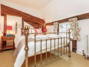 灵格弗尔德Pollard Cottage的一间卧室设有一张床和一个窗口
