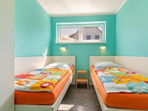 齐罗Beautiful Seaside Holiday Home in Zierow的蓝色墙壁客房的两张床
