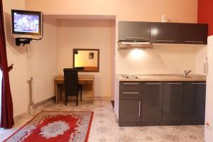 米特罗维察Hotel North City的厨房配有书桌和墙上的电视。