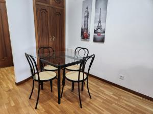 奥伦塞Estudio con vistas a la ciudad的一张黑色餐桌,配有两把椅子和一张照片