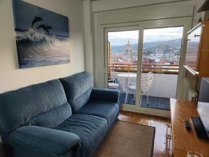 奥伦塞Estudio con vistas a la ciudad的一间带蓝色沙发的客厅和一个阳台