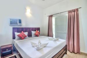 卡兰古特Santa Monica Resort - Calangute的卧室配有一张大白色床和窗户