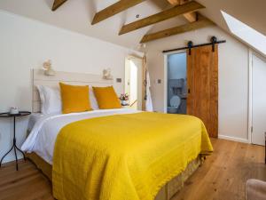 温彻斯特Mallard Cottage的一间卧室配有一张带黄色床罩的大床