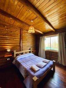 卢汉德库约Mirador de Montaña的木制客房内的一间卧室,配有一张床