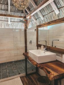 El LimónMonoloko Lodge Popoyo的浴室设有白色水槽和镜子