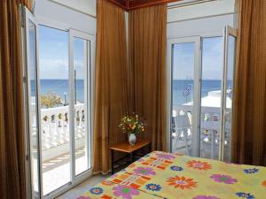 阿吉亚特拉萨爱哥恩酒店的一间卧室设有一张床和一个海景阳台