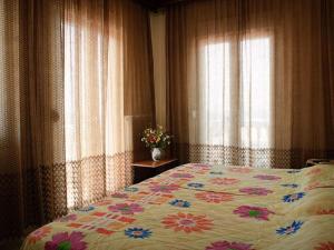 阿吉亚特拉萨爱哥恩酒店的一间卧室配有一张带花卉图案的被子的床